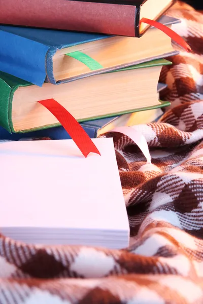 Many books with bookmarks on plaid close-up — Stock Photo, Image