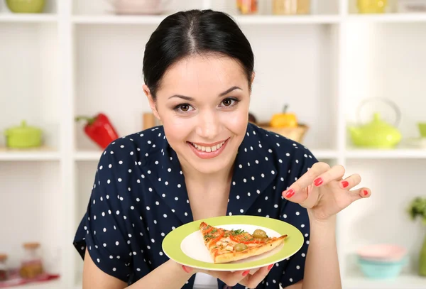 Meisje met heerlijke pizza op keuken achtergrond — Stockfoto