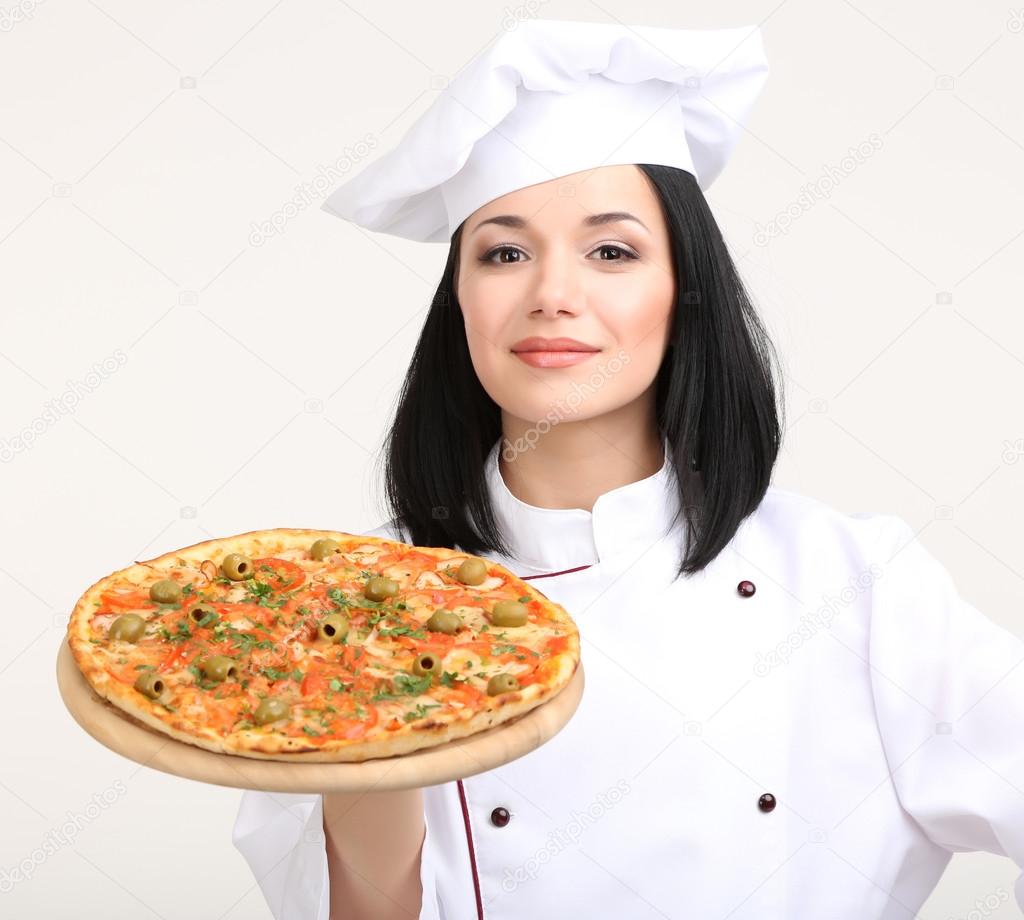 Beautiful girl chief-cooker with pizza isolated on white