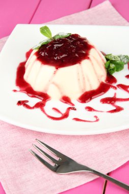 Panna cotta renk ahşap zemin üzerinde frambuaz sos ile