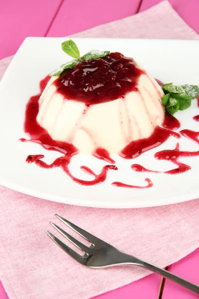 Panna cotta renk ahşap zemin üzerinde frambuaz sos ile — Stok fotoğraf