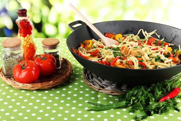 Nudlar med grönsaker på wok på natur bakgrund — Stockfoto