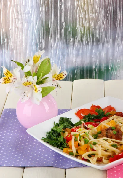 Nouilles aux légumes dans une assiette sur une table en bois — Photo