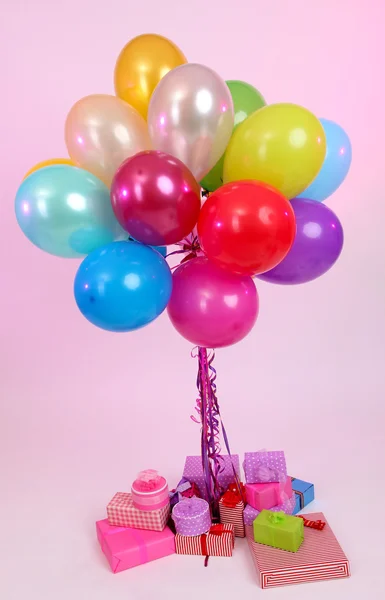 Veel heldere ballonnen en vele geschenken op lichte achtergrond — Stockfoto