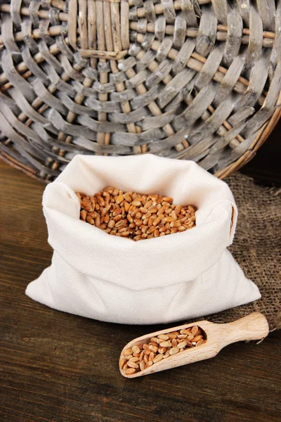 Grains in sack on wooden background — Stock Photo, Image