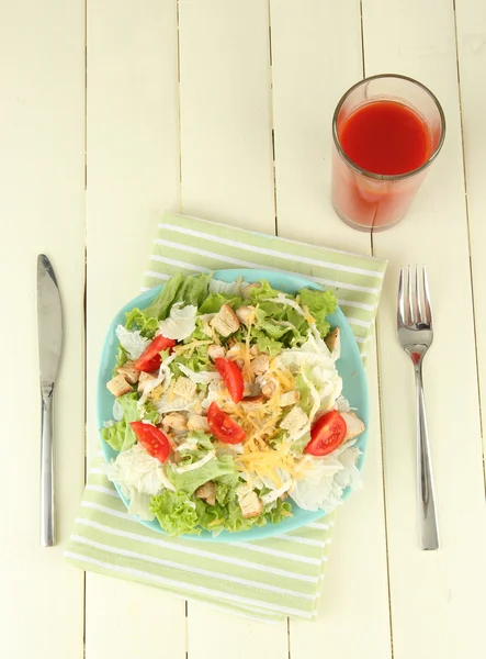 Caesar-Salat auf blauem Teller, auf farbigem Holzhintergrund — Stockfoto