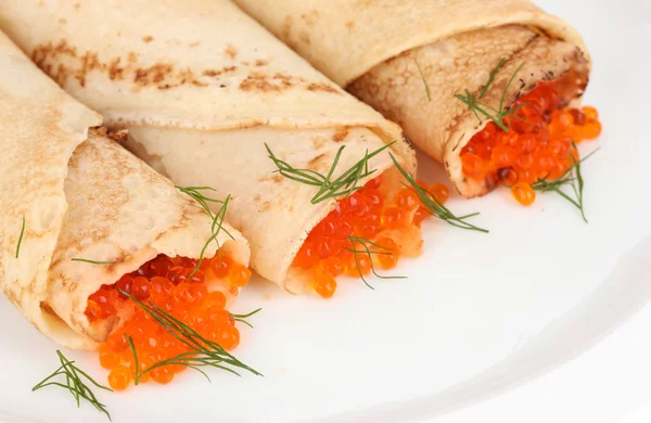 Läckra pannkakor med röd kaviar på plattan närbild — Stockfoto