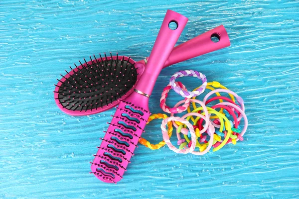 Scrunchies, hairbrush and hair - clip on a blue background — Stock Photo, Image