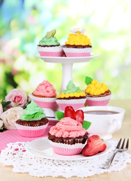 Mooie cupcakes op eettafel op natuurlijke achtergrond — Stockfoto