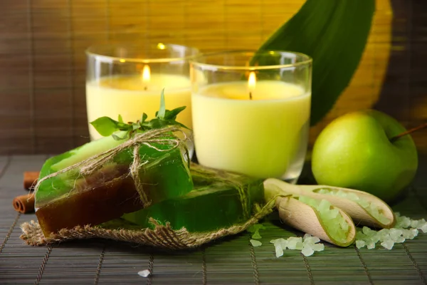 Sapone fatto a mano e candele su sfondo tappetino di bambù — Foto Stock