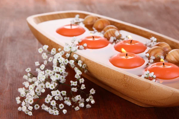 Hermosas velas en el agua en la mesa de madera primer plano — Foto de Stock