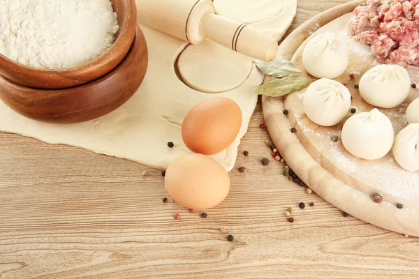 Raw dumplings, ingredients and dough, on wooden table — Stock Photo, Image