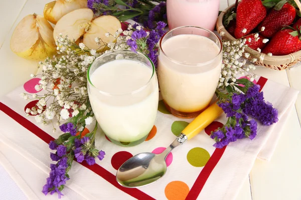 Deliciosos yogures con frutas en vasos sobre mesa de madera — Foto de Stock