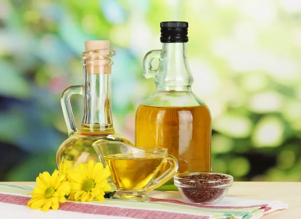 Useful linseed oil on wooden table on natural background — Stockfoto