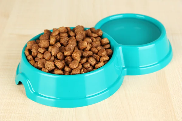 Nourriture sèche pour chien dans un bol sur fond en bois — Photo