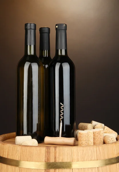Wijn en kurken op vat op bruine achtergrond — Stockfoto