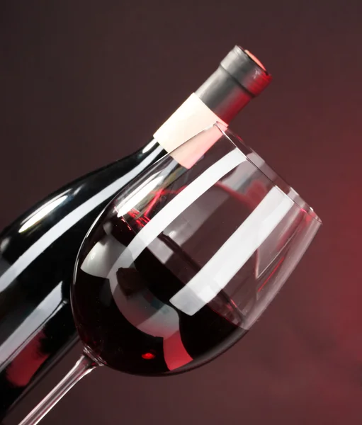 Wine in glass and wine bottle close-up on dark background — Stock Photo, Image