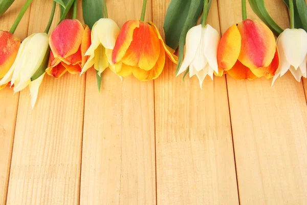 Красивые белые и оранжевые тюльпаны на деревянном фоне — стоковое фото