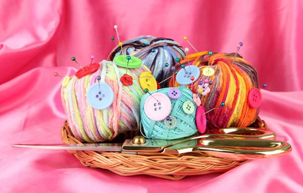 Colorful buttons and multicolor wool balls, on color fabric background — Stock Photo, Image
