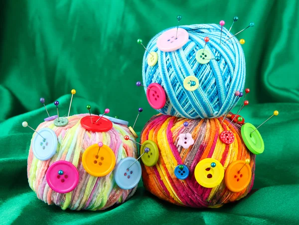 Boutons colorés et boules de laine multicolore, sur fond de tissu couleur — Photo
