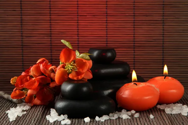 Spa stones with flowers and candles on bamboo background — Stock Photo, Image