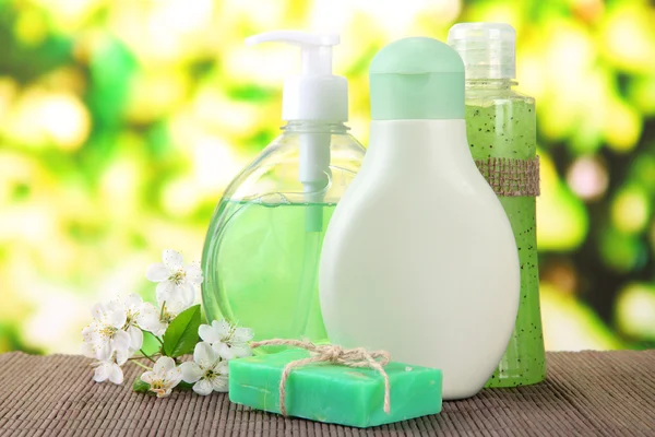 Cosmetics bottles and natural handmade soap on green background — Stock Photo, Image