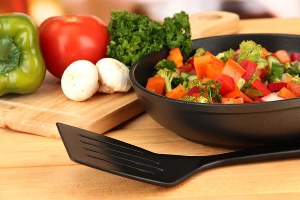 Vegetable ragout in pan, on wooden table on bright background — Stock Photo, Image