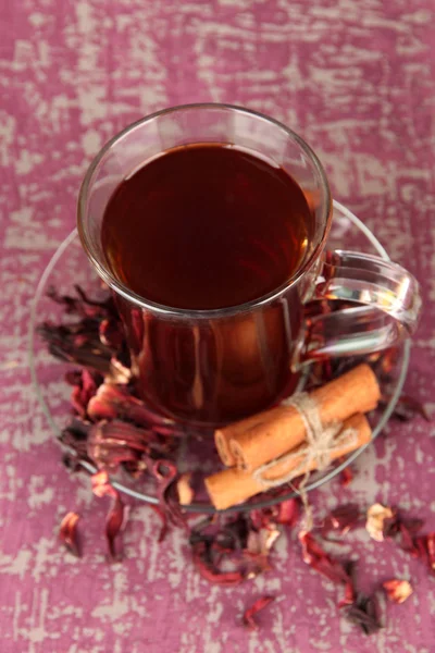 Tè alle erbe in tazza di vetro, su sfondo di legno a colori — Foto Stock