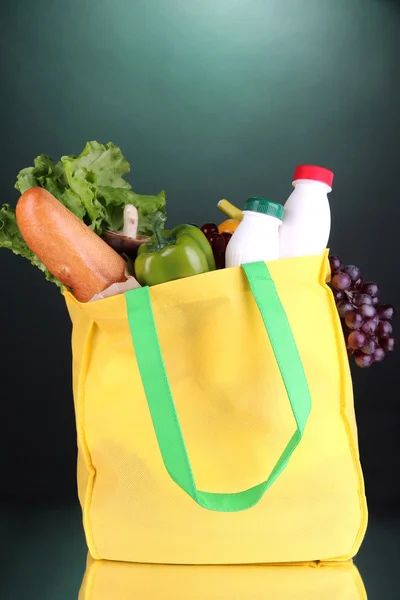 Öko-Tasche mit Einkauf auf dunkelgrünem Hintergrund — Stockfoto