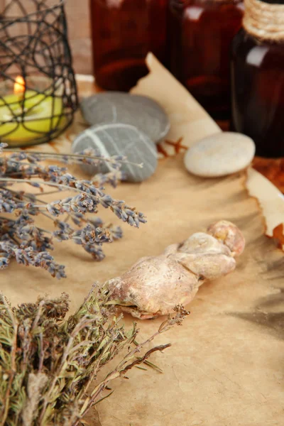 Composition with old papers, herbs, stones and bottles with symbols on wooden background — Stock Photo, Image