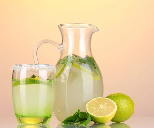 Limonada em jarro e vidro sobre fundo amarelo — Fotografia de Stock