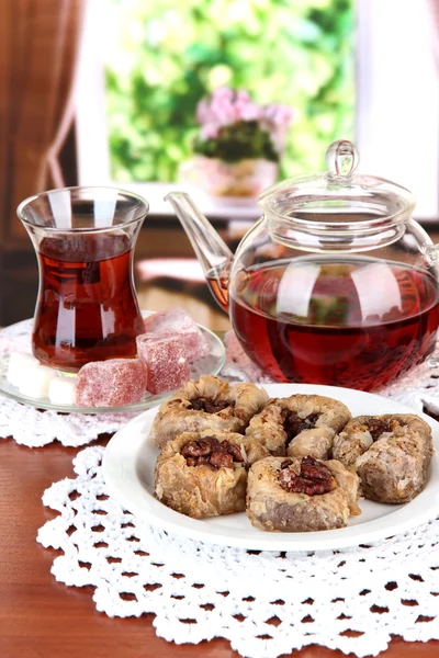 Sweet baklava on plate with tea on table in room — Stock Photo, Image