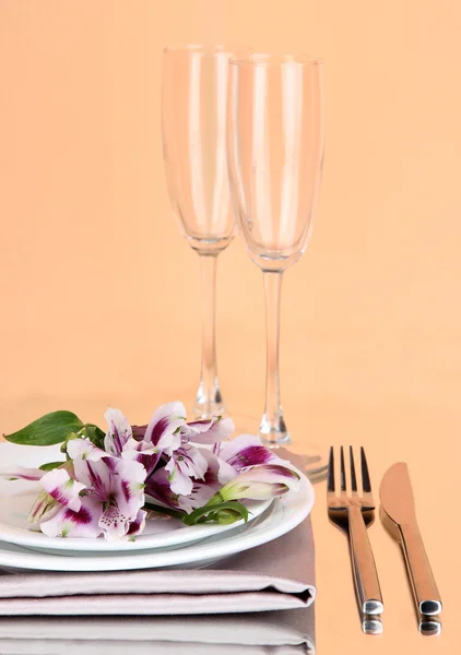 Ajuste de mesa festivo con flores sobre fondo melocotón —  Fotos de Stock