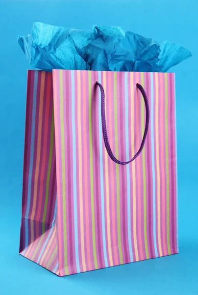 Striped shopping bag on blue background — Stock Photo, Image