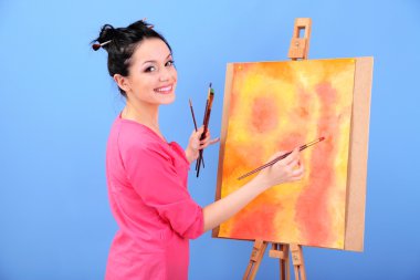 güzel bir genç kadın ressam anda, renkli arka plan üzerinde