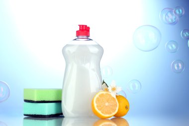 sünger ve çiçekli mavi zemin üzerine limon ile bulaşık deterjanı