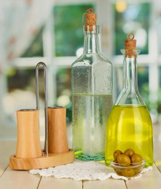 Özgün cam şişeler penceresi arka plan üzerinde ahşap masa üstünde salata sosu ile