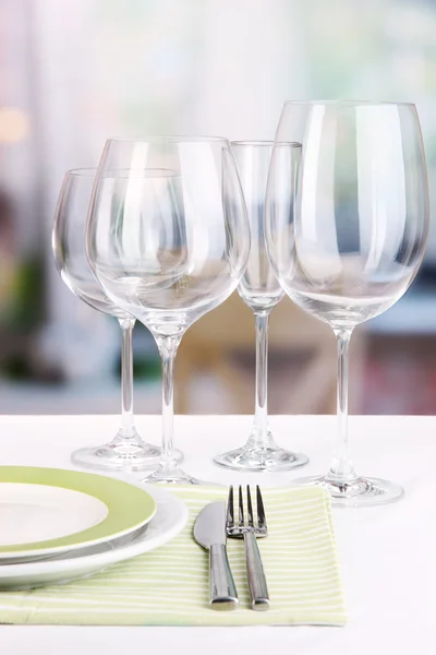 Configuração de mesa com copos para diferentes bebidas na mesa no fundo do quarto — Fotografia de Stock