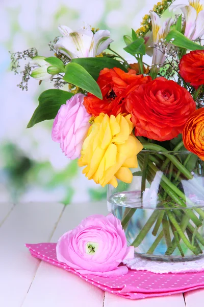 Uitstekende buttercup bloemen in glazen vaas op houten tafel op natuurlijke achtergrond — Stockfoto