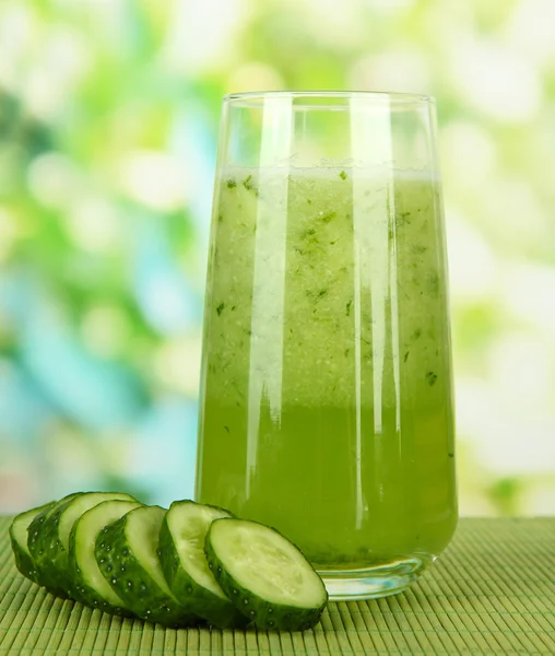 Copo de suco de pepino, em esteira de bambu, em fundo verde — Fotografia de Stock