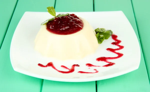 Panna Cotta with raspberry sauce, on color wooden background — Stock Photo, Image