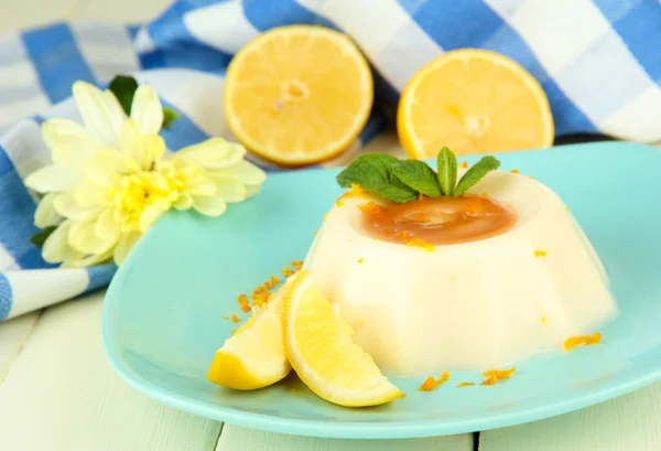 Limon panna cotta portakal lezzet ve renk ahşap zemin üzerine karamel sosu ile — Stok fotoğraf