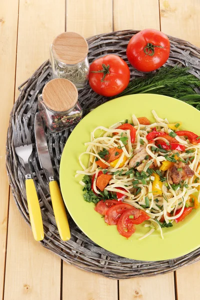 Nudeln mit Gemüse auf Tellern auf Holzgrund — Stockfoto