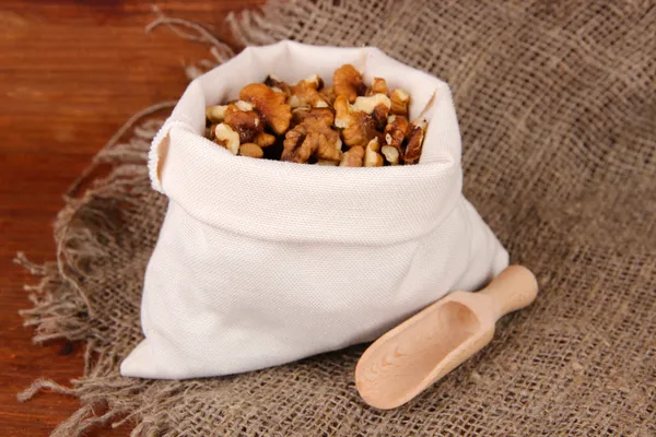 Nuts in sack on wooden background — Stock Photo, Image