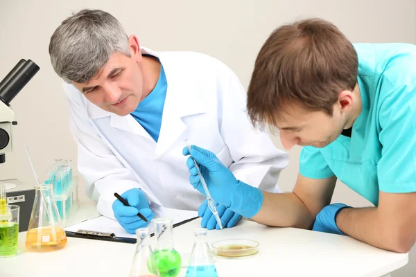 Physician and assayer during research on room background — Stock Photo, Image