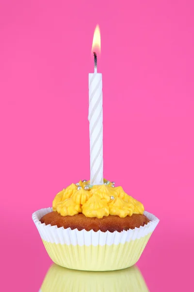 Belo cupcake com vela no fundo rosa — Fotografia de Stock