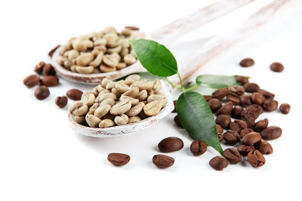 Green and brown coffee beans in wooden spoons and leaves isolated on white — Stock Photo, Image