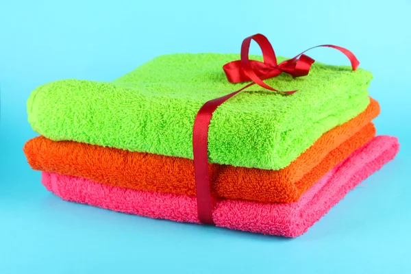 Towels tied with ribbon on light blue background — Stock Photo, Image