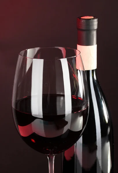 गडद पार्श्वभूमीवर काच आणि वाईन बाटली मध्ये वाईन जवळ-अप — स्टॉक फोटो, इमेज