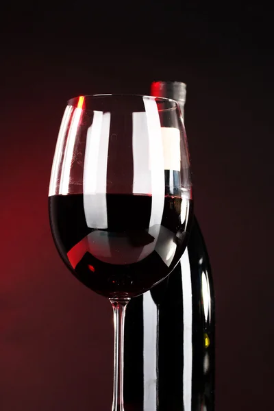 Wine in glass and wine bottle close-up on dark background — Stock Photo, Image